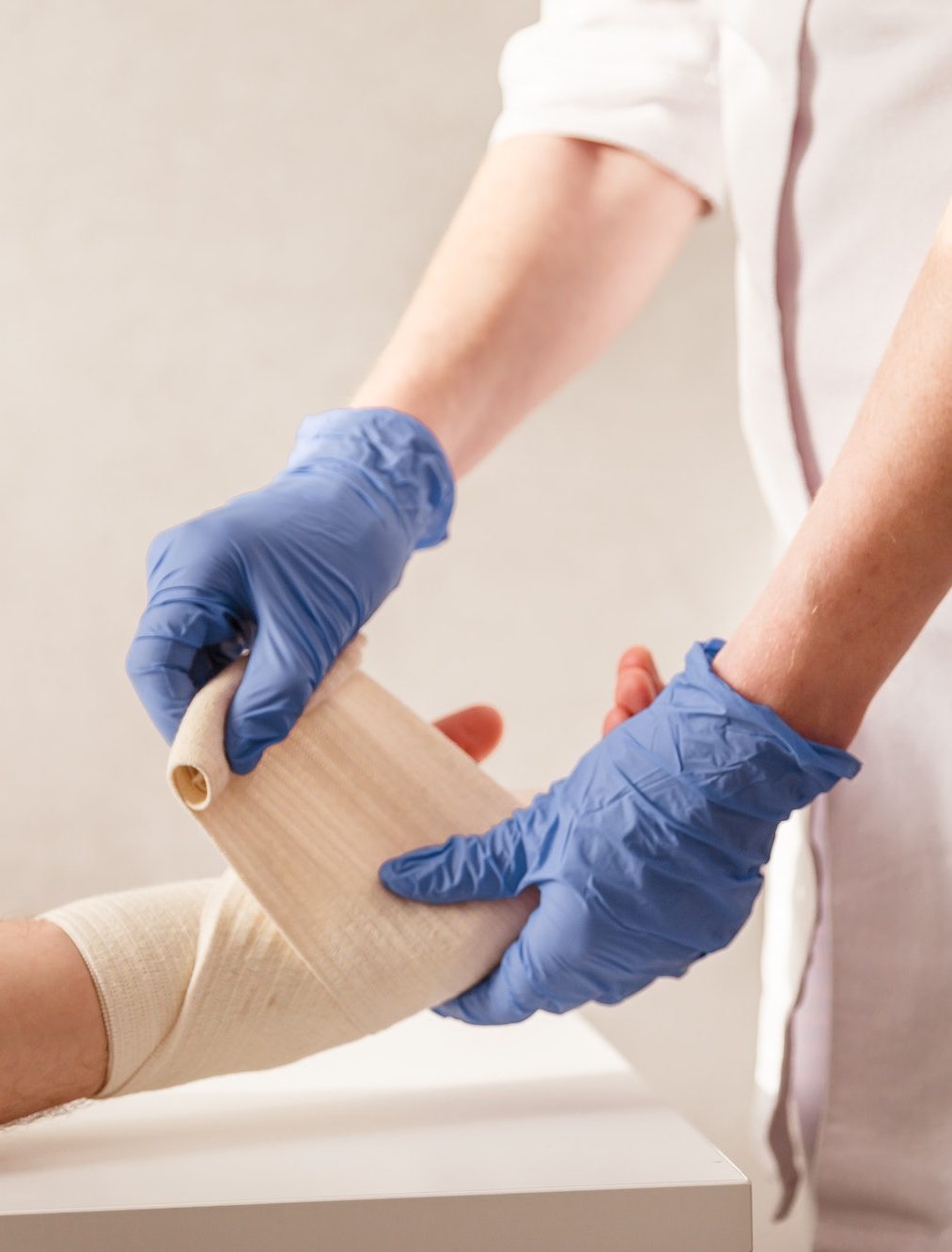 Doctor imposes an elastic bandage to the patient wrist. Rehabilitation after sprain