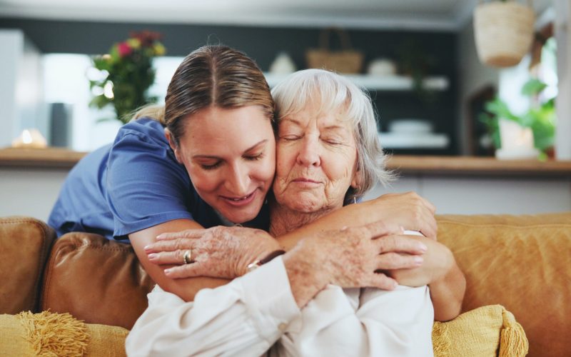 Happy woman, nurse and hug with senior patient in elderly care, love or nursing at retirement home