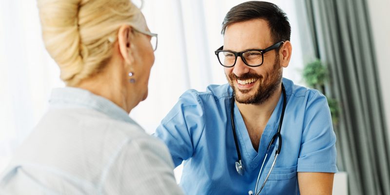 Doctor or nurse caregiver with senior woman at home or nursing home
