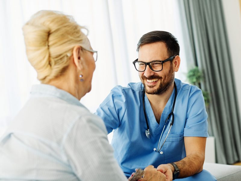Doctor or nurse caregiver with senior woman at home or nursing home